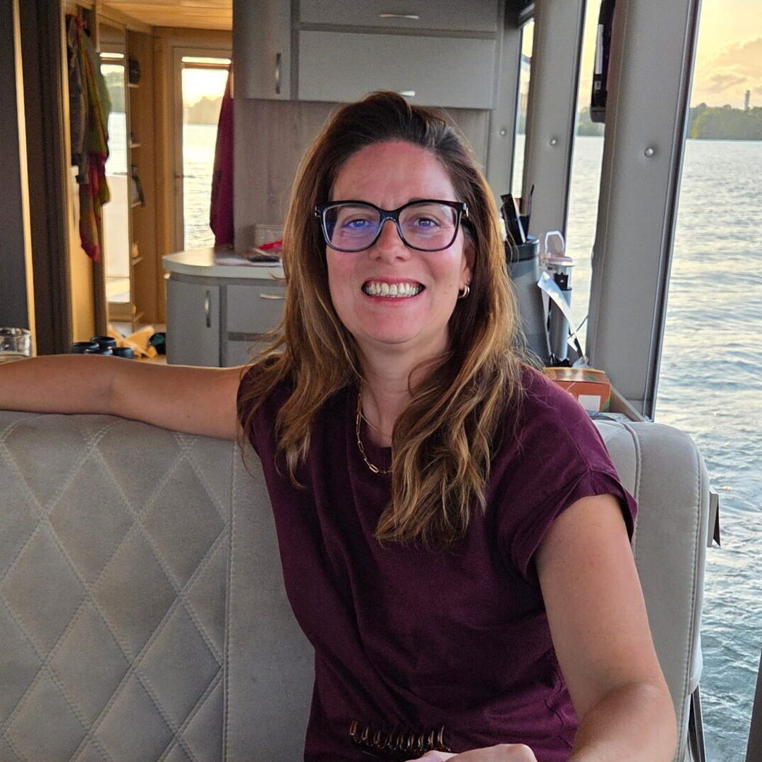 Alexandra, medewerker administratie en planning bij Bendabouw, lachend met bril